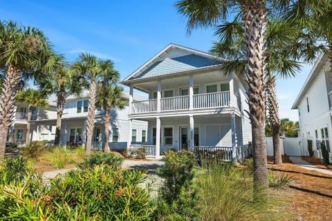 Coastal charm awaits at this stunning beach house, complete with covered balconies and tropical landscaping in a peaceful neighborhood setting.
