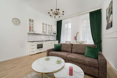 A stylish living room with a sofa, elegant curtains, and bright space invites you to relax after a day exploring Wrocław.