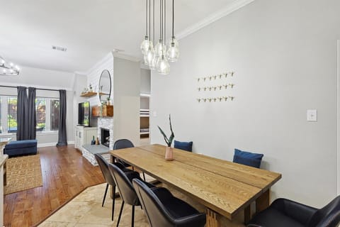 Featuring a wooden dinner table, a bench, and five mid-century modern chairs, this stylish dining area has a restaurant-like feel and enough seating for at least eight guests.