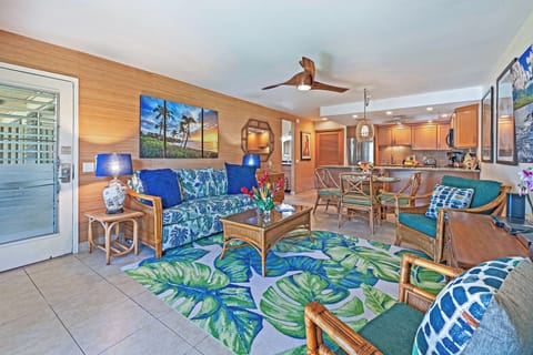 In Kahana Sunset B4B, the open living space boasts vibrant tropical décor and flows into dining and kitchen areas.