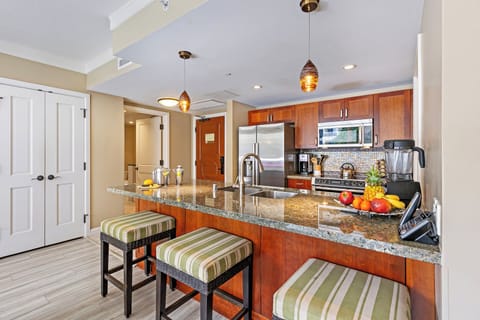 Chef’s kitchen at Hokulani 214 'Kamalu' with cherry cabinets, granite counters, and Bosch appliances.