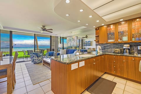 The open kitchen at Papakea L-106 features modern finishes and flows effortlessly into the living area and oceanfront lanai—perfect for relaxed island living