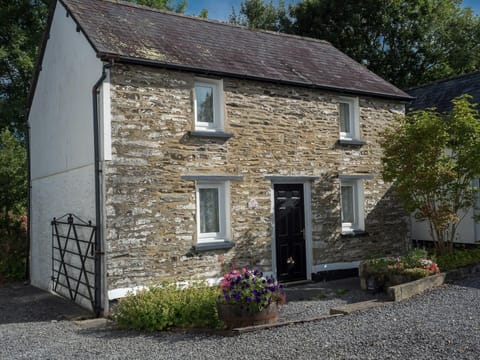 Stone cottages with gravel drive way and tubs of flowers outside the front door