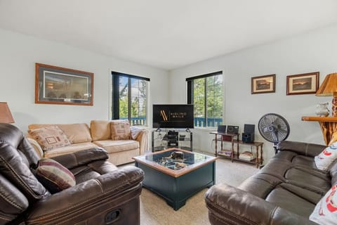 Main living room on the second level of the home with a TV, board games & access to the patio.