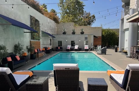 Unwind poolside on plush loungers beneath charming café lights.