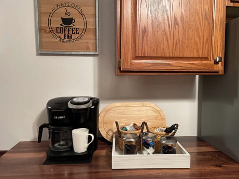 Coffee bar stocked with starter supply of coffee and creamer and sweeteners.
