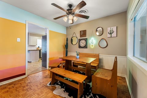 The multipurpose seating area has a ceiling fan and is nearby the kitchen