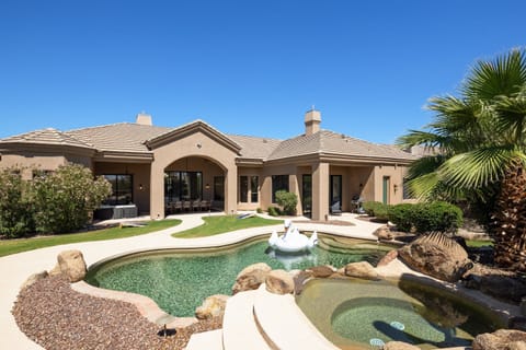 Beautiful Backyard featuring a sparkling pool, hot tub, private patio with outdoor furniture and an outdoor dining table, grill, fire pit, and corn hole set.