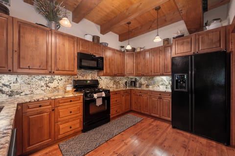 - Spacious kitchen with granite countertops and storage   - Black appliances and wood cabinets for modern comfort   - Fully equipped for cooking, baking and family meals