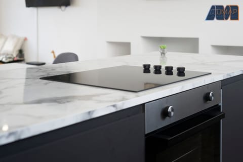 Cook in style with this sleek, modern kitchen featuring a marble countertop and state-of-the-art appliances.