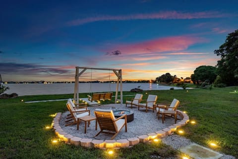 "Sunset Serenity: Gather Around the Fire Pit with Comfortable Seating and Enjoy the Picturesque Waterfront Views, Perfect for Evening Relaxation."