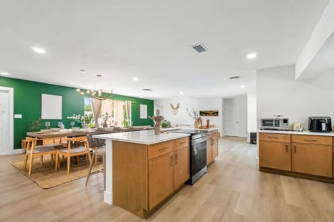 "Modern Culinary Space: Open-Concept Kitchen Overlooking the Dining Area and Living Room with Sleek Appliances and Ample Counter Space."