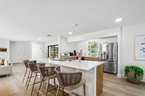 "Inviting Kitchen Bar: Spacious Island with Seating, Perfect for Casual Dining or Entertaining, Complemented by Stainless Steel Appliances."