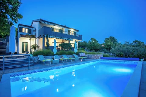 Take a nighttime look at the pool area and the villa itself.
