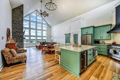 Beautiful open kitchen and living area with vaulted ceilings, a large island, and stunning floor-to-ceiling windows showcasing lake views