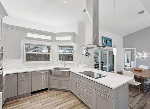 Fully stocked kitchen with electric range top and quartz countertops.