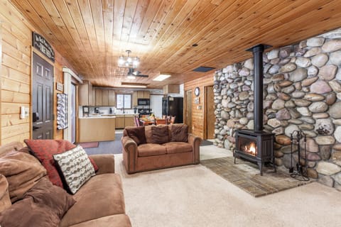 Relax in the comfortable living area, where cozy sofas and a charming fireplace create the perfect setting to unwind at Raven's Retreat.