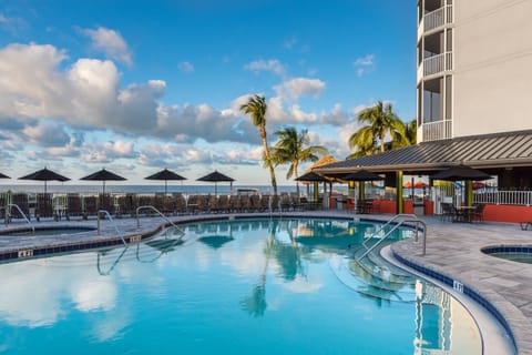 Linger in calm blue waters as palms sway nearby.