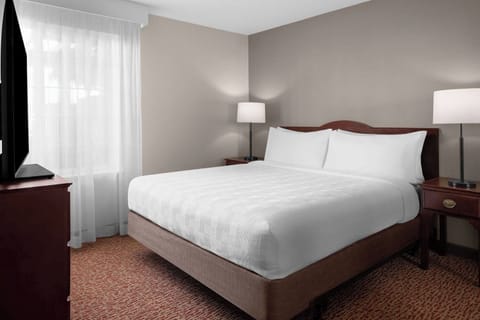 Relax into a serene king bed under soft lighting.