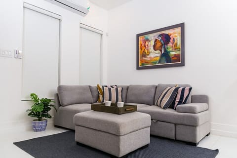 Bright living room w/ comfy sectional, ottoman coffee table & colorful wall art for relaxed evenings