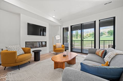 Experience the main floor living room, outfitted with plush seating, large Smart TV, and an electric fireplace.