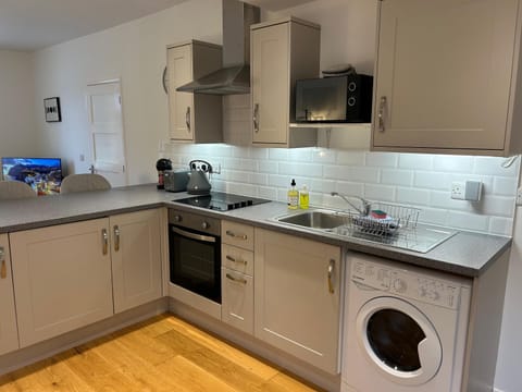 A fully stocked kitchen with a washer/dryer unit. 