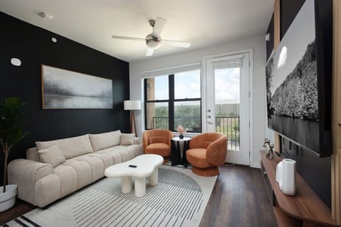 Unwind in our living room, featuring a spacious, cozy sofa, large TV, and beautiful touches of art.