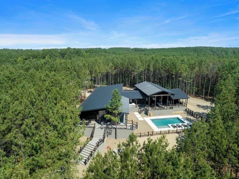 Secluded forest cabin with modern design, private pool, multiple decks, and lush tree surroundings.