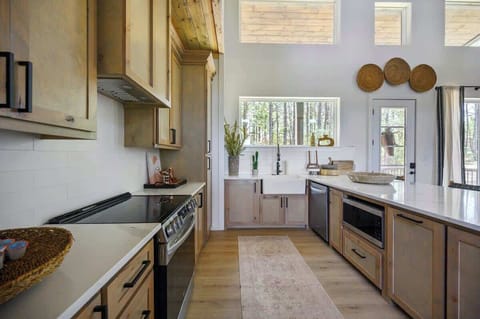 Bright kitchen with natural light, custom wood cabinetry, and stainless steel appliances for a luxury cabin feel.