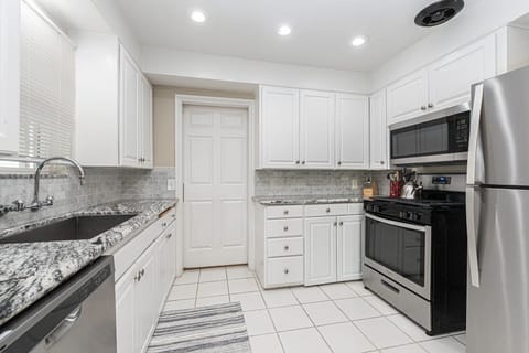 Updated kitchen with granite countertops, stainless steel appliances, and crisp white cabinetry for effortless cooking
                