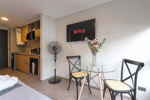 Cozy living space with a modern kitchenette and entertainment setup, perfect for a relaxing stay.