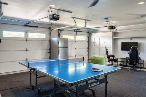 Garage has been converted into a games room with table tennis, darts, and a games console.