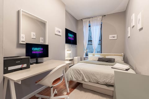 Bright bedroom with workspace, smart TV & cozy queen bed