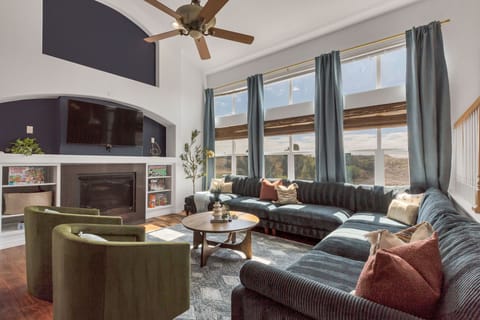 Spacious living room with TV, fire place, ceiling fan. and expansive views