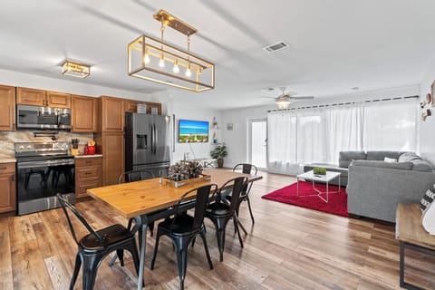 Open clean kitchen that flows into the living room with a table for six