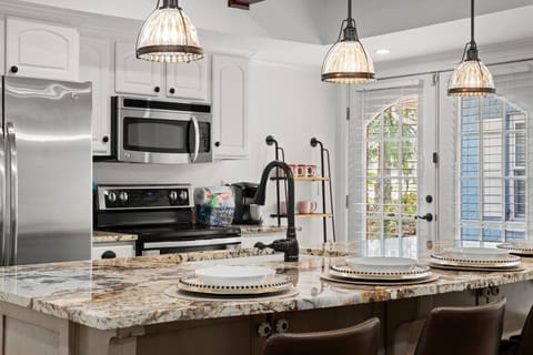 A bright and updated kitchen with outdoor access, fully stocked with all the essentials you'll need for a relaxing stay, making cooking and dining a breeze.