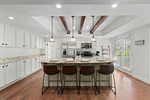 A bright, updated kitchen with sleek stainless steel appliances, a breakfast bar island, and fully stocked with everything you need for a convenient and enjoyable stay!