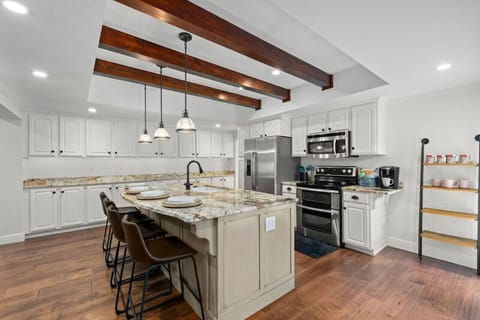 A bright, updated kitchen with sleek stainless steel appliances, a breakfast bar island, and fully stocked with everything you need for a convenient and enjoyable stay!