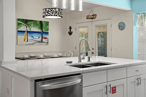 An open, updated kitchen with bright natural light, featuring sleek stainless steel appliances and a stylish breakfast island perfect for casual meals.