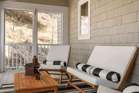 Beautiful seating with cabana stripes and warm wood tones in the three seasons porch