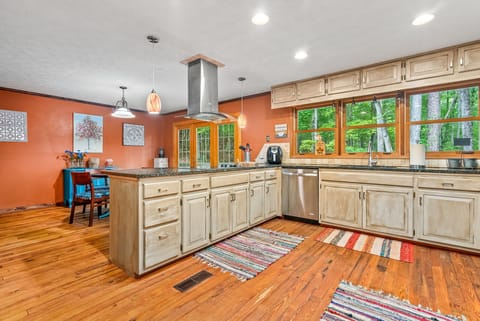 Enjoy cooking in this modern, open-concept kitchen, fully stocked with all the essentials for preparing any meal. The large windows offer views of the surrounding nature, while the open layout ensures you're never far from the ongoing conversations a