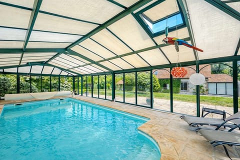 Heated indoor pool filled with natural light, with sun loungers and views over the lush garden.
A relaxing space to enjoy in every season, sheltered under a glass enclosure, perfect for a family or friends getaway in Normandy.