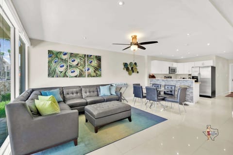 The living room area features a plush sofa facing the large flatscreen Smart TV with cable