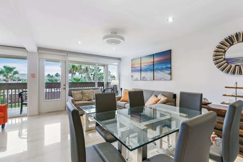 The dining area features a glass table that comfortably seats