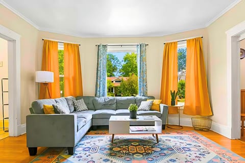 Lounge in a sun drenched living room w/ vibrant curtain & comfortable furnishing