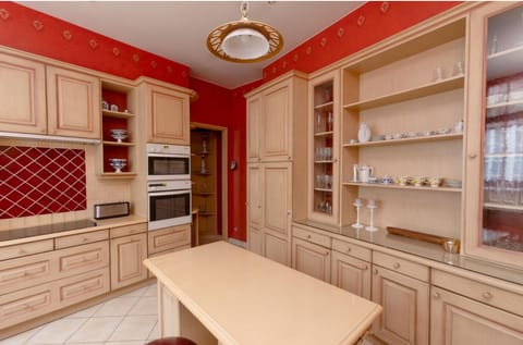 Kitchen is traditionally laid out with blonde wooden cabinets,latest appliances