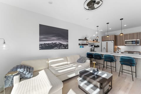 Relax in your stylish open-concept living space with modern furnishings and a fully equipped kitchen featuring sleek appliances.