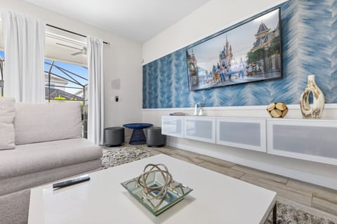 - Relax in a modern living area featuring comfortable seating and sleek design - Large windows and sliding doors offer natural light and poolside views - Ideal for relaxation, featuring a smart TV and contemporary décor