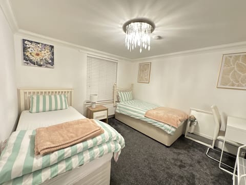Main front bedroom with 2 single beds plus table and a chair for work.