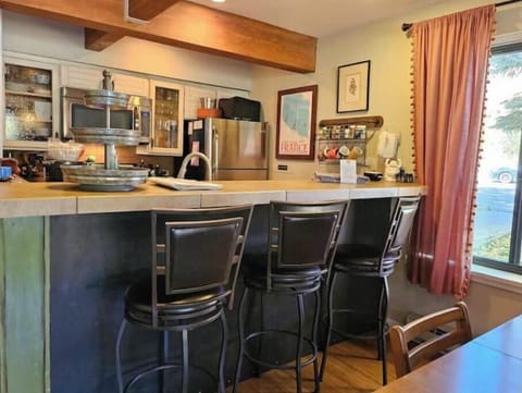 Counter and barstools looking into galley kitchen